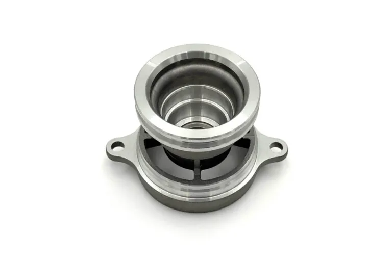 Close-up of a precision CNC machined aluminum component with tight-tolerance bores and a smooth surface finish.